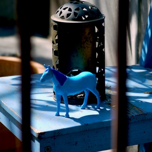 UN cheval bleu et une lanterne posés sur une chaise bleue derrière des barreaux - Belgique  - collection de photos clin d'oeil, catégorie clindoeil